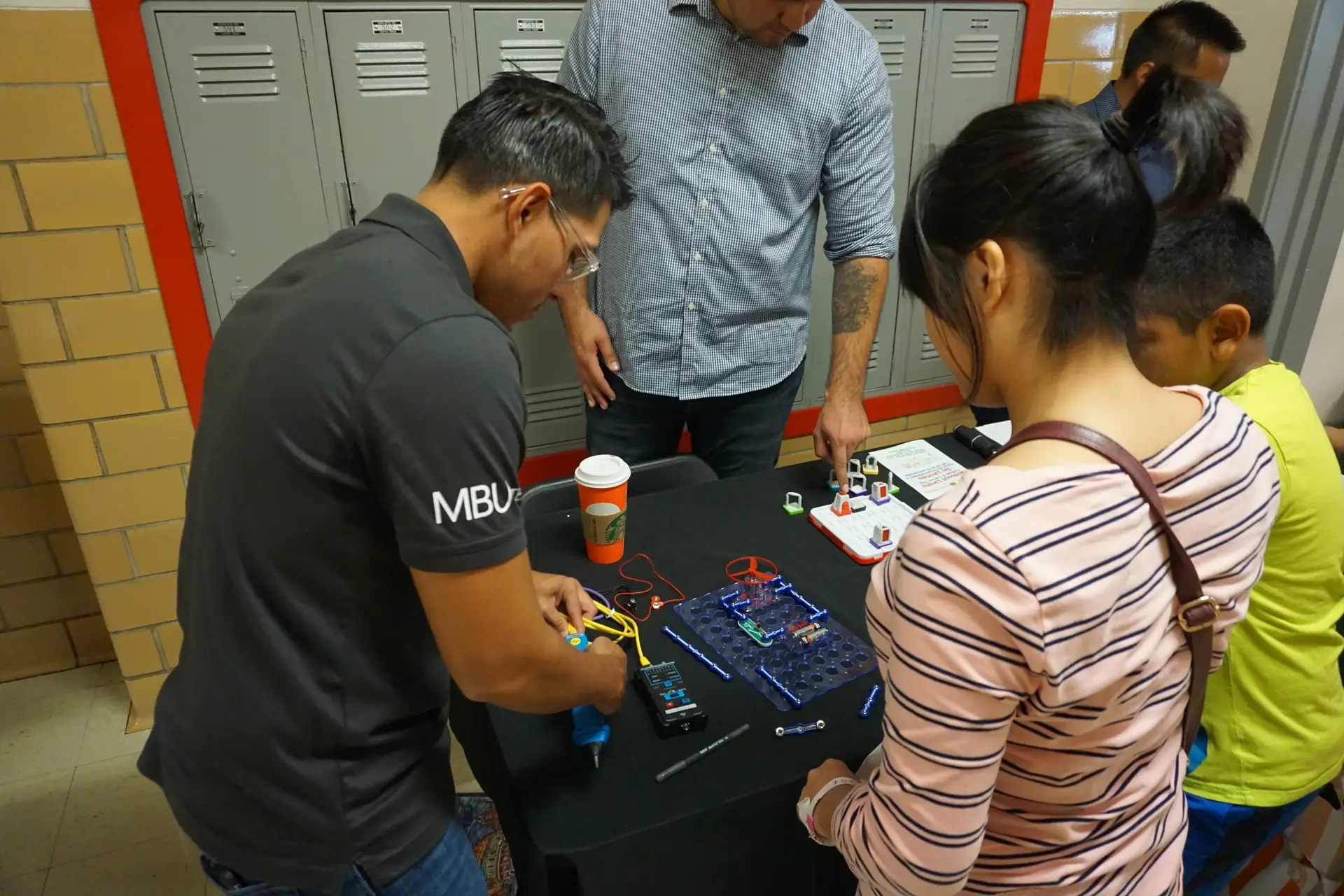 Hands-on We Can Change IT technology workshop showing participants using cybersecurity and technology equipment.